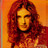 Pixelated portrait of a person with long dark hair against an orange background, rendered in warm red and yellow tones.