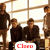 Group of people in dark clothing seated and standing against a -patterned background with red 'Claro' text below them