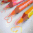 Animated sequence showing colorful pencil-like shapes with heart ends moving across a light background, transitioning to static icons including peace signs and smiley faces.