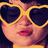 Pixelated close-up of a person wearing large yellow-framed sunglasses with dark lenses, pink lips, and light skin tone.