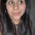 Pixelated close-up of a person with long dark hair wearing a dark top against a muted background.