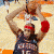 A basketball player in a dark jersey with 'CARTER' and number 15 on the back, holding a red boxing glove above his head while standing on a court.
