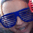 A person wearing blue shutter shades with red hair accessories, animated text elements forming 'DANCER!' across frames.