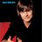 Pixelated image of a person with brown hair and red clothing on black background, next to bright pink with blue text
