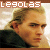 Pixelated image of a person with light brown hair and dark clothing, featuring text reading 'LEGOLAS' in white block letters on a brown banner at the top.
