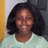 Pixelated portrait of a person with dark curly hair wearing light-colored clothing against a two-toned background.