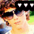 A pixelated image of a person wearing sunglasses and a white top, with three heart icons above the head, set against an outdoor background.