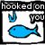 Pixelated icon shows blue fish on hook with text 'hooked on you' in black and white border.