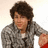 Pixelated image of a person with curly brown hair in a gray checkered shirt, next to orange background with yellow text reading "they were thinking about it and... they couldnt leave without taking us TO THE YEAR 3000".
