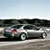 Pixelated image of a silver sedan with red accents on a road, dark background, and light sky.