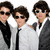 Three pixelated figures in formal attire with dark hair and sunglasses, standing side-by-side against a white background.