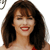 Pixelated close-up of a person with long dark brown hair, red lipstick, and a red garment visible at the bottom right, set against a white background.