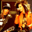 Two pixelated figures in orange and brown tones, one wearing a cap with a dark brim and light top, the other with long hair, both rendered in low-resolution style.