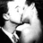 Black-and-white animation of a man and woman in formal attire kissing, smiling, and embracing across four