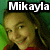 Pixelated image of a person with light brown hair and green eyes, wearing red clothing against a green background with white text reading 'Mikayla' at the top.