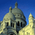 Pixelated image of a domed building with multiple spires against a solid blue background, rendered in low-resolution style with visible pixelation.