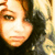 A pixelated close-up of a person with long wavy hair, showing subtle variations in facial expression and lighting