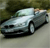 Pixelated silver sedan with dark trim on a blurred background, viewed from a low angle showing front and side profile.
