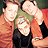 Three people pose closely together in a pixelated image with green text reading 'Green Day' on the right side.
