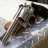 Pixelated static image of a dark-colored vehicle with visible wheels and body structure against light background.