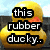 Yellow rubber duck with orange beak and black eye, positioned against blurred background with text overlays.