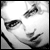 Black-and-white pixelated icon showing a partial face with visible eye, eyebrow, and mouth details against a light background.