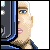 Pixelated profile view of a person with light skin, blue eyes, and short white hair partially obscured by dark vertical shapes.
