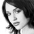Black-and-white pixelated portrait of a person with dark hair and neutral expression, rendered in low-resolution grayscale style on white background.