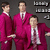 Three men in matching magenta suits stand against a dark gray background with partial text elements visible on the right.