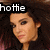 A pixelated image of a person with dark curly hair, showing two side-by-side views with slight facial expression changes and text elements.