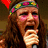A person with long brown hair and a colorful headband sings into a microphone, with text reading "Juliette And The Licks" on a black background.
