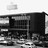 Black-and-white pixelated image of a building facade with dark rectangular windows and a lighter horizontal band across the middle.