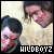 Pixelated image of two people with dark hair against a light background, featuring bold white text at the bottom.