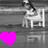 A grayscale pixelated image shows a figure seated at a desk with a chair, while a bright pink and purple color block appears in the bottom-left corner.