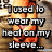 A pixelated image of a person in an orange top with a pink heart on the sleeve, overlaid with text about wearing heat on sleeves.