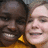 Two people in yellow shirts smile together, with pixelated text overlays reading "okay. so shes black and im white as mess" and "but shes still my 2nd grade HERO!"