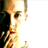 Pixelated static image of a person's face with visible facial features and partial body, rendered in warm tones on a white background.