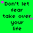 Green background with repeated text "Don't let fear take over your life" in black pixelated font, scattered pink and purple star shapes.