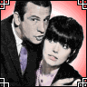 Two people in formal attire stand close together against a red gradient background with black-and-white geometric corner borders; text appears in the lower-left and upper-right
