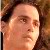 Pixelated close-up of a person's face with light skin tone, dark hair, and neutral expression against a brown-toned background.