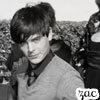 Black-and-white photo of a person with dark hair and bangs wearing a light-colored shirt, with a blurred background and a '700' watermark in the bottom right.