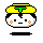 Pixelated cartoon head with yellow hair, green T-shaped accessory, white face, black eyes and mouth, orange cheek dots on gray background.