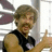 Pixelated image of a person with light brown hair and mustache giving a thumbs-up gesture, surrounded by pink pixelated text on black background.