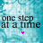 repeated text "one step at a time" with pink heart symbols on a blue and white patterned background