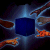 A pixelated blue cube surrounded by four brown and orange shapes against a dark background.