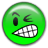 Green circular cartoon face with one eye winking, a wide toothy grin showing white teeth and black outlines, pixelated style on transparent background.