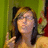 Pixelated static image of a person with long dark hair and light skin, wearing a yellow top, against a green background with red and brown elements.