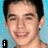 A pixelated portrait of a person with short dark hair against a light blue background, featuring text overlays in black rectangular boxes.