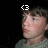 Pixelated close-up of a person's face with a white pixelated symbol above the head on a black background.