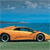 Pixelated orange sports car on green grass with blue water and sky background, static image with no visible text or animation.